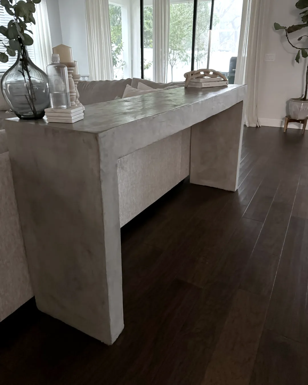 The finished hallway table, a pale concrete-finish console against a window
